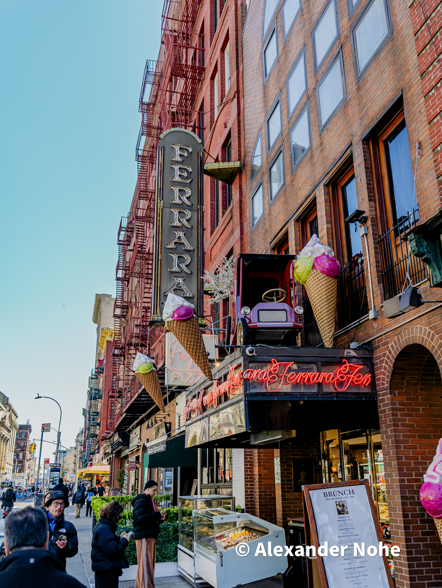 The entrance to Ferrara Bakery & Cafe with outdoor seating