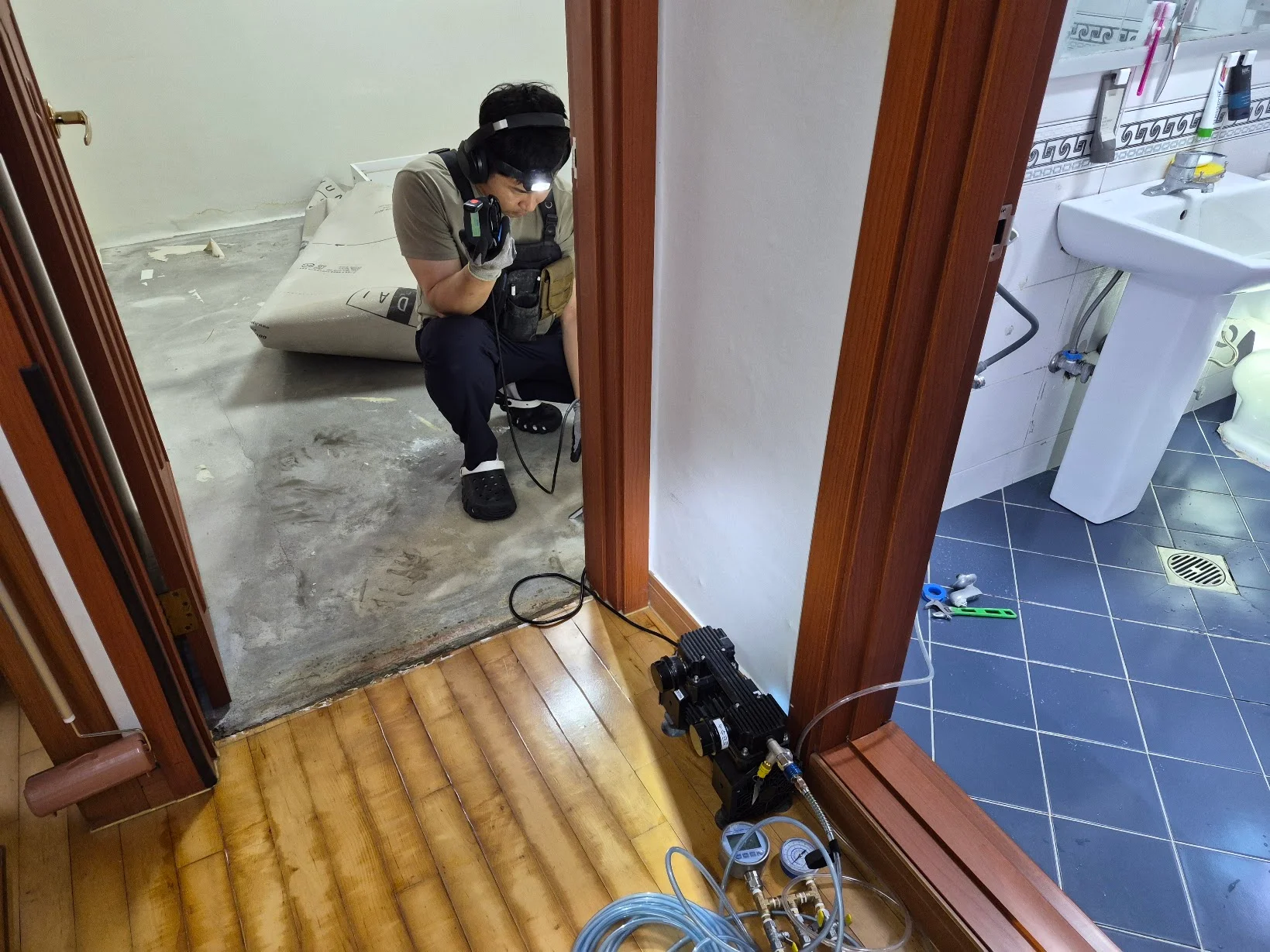 누수 탐지 장비로 바닥을 점검하는 기사