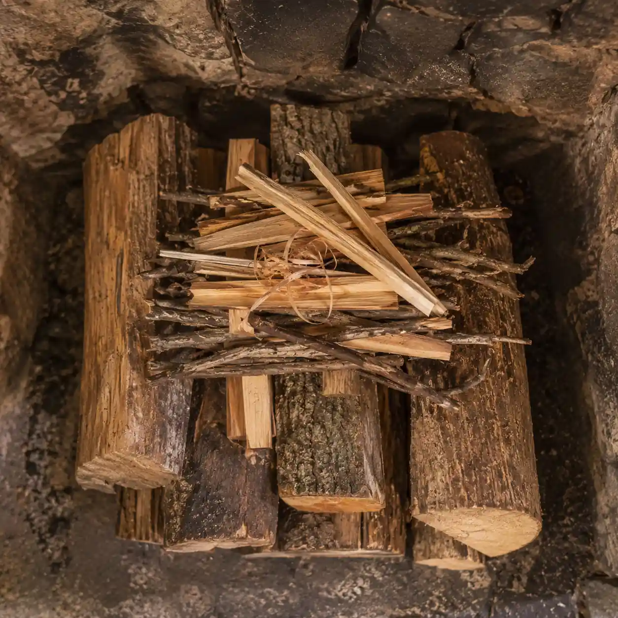 Top-down fire method with logs stacked in a stone fireplace
