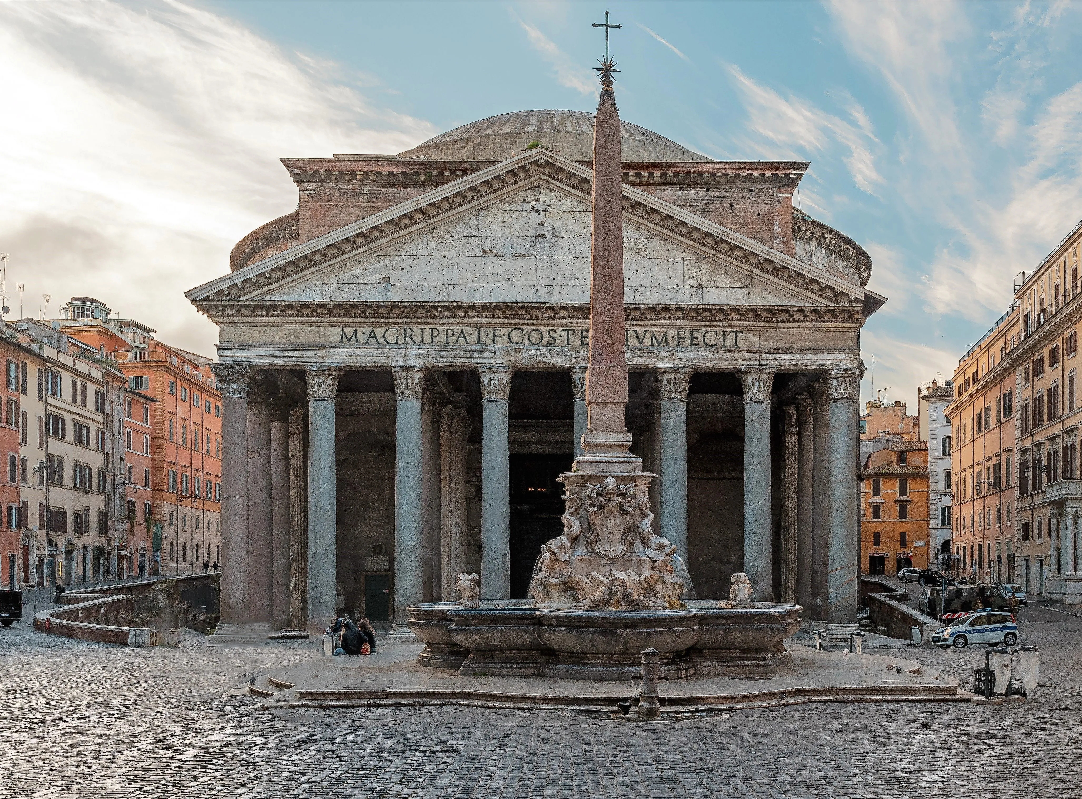 An eye-level, well-composed photograph of the Pantheon in Rome, Italy, showcasing its classical facade, the columns, and the iconic dome, with the Fontana del Pantheon and the Obelisco Macuteo prominently in the foreground. The image captures the historical landmark with impressive detail and clarity.