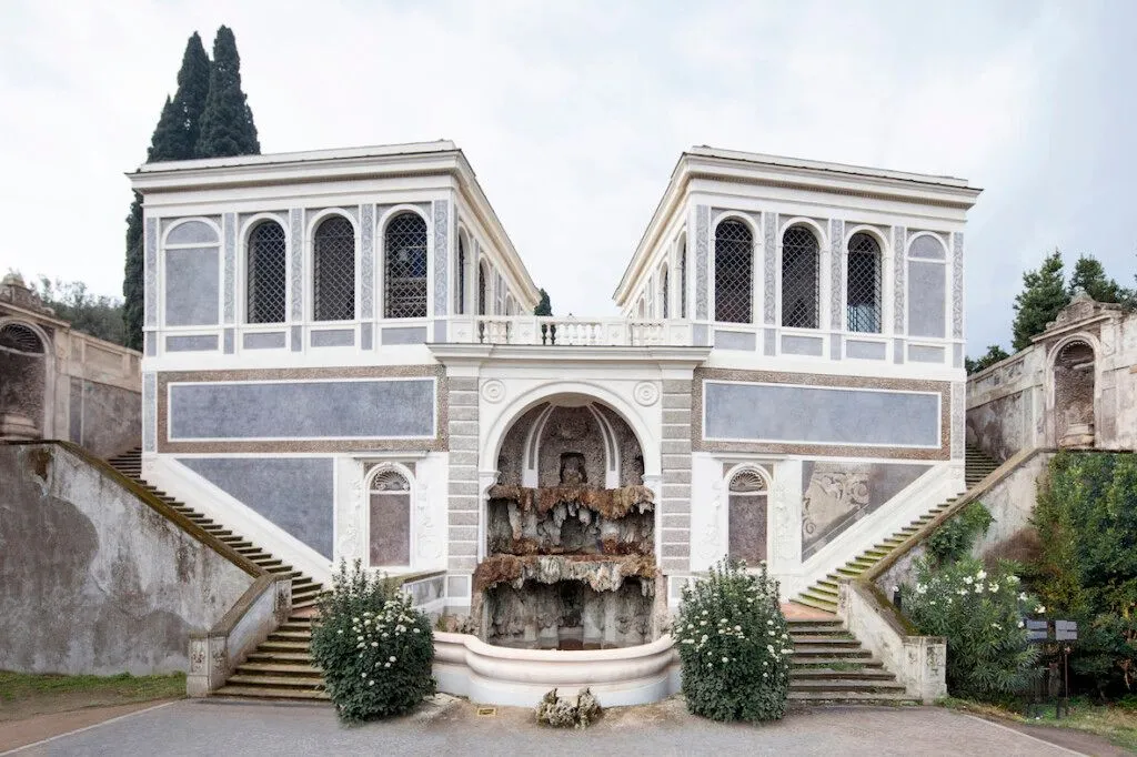 A well-composed and balanced photograph of an architectural structure with a central fountain and symmetrical staircases, set under even lighting.