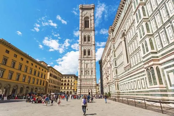 A well-composed, well-lit, and sharp photograph of Giotto's Campanile and the Florence Cathedral (Duomo) in Florence, Italy, capturing the bustling Piazza del Duomo under a bright sky.