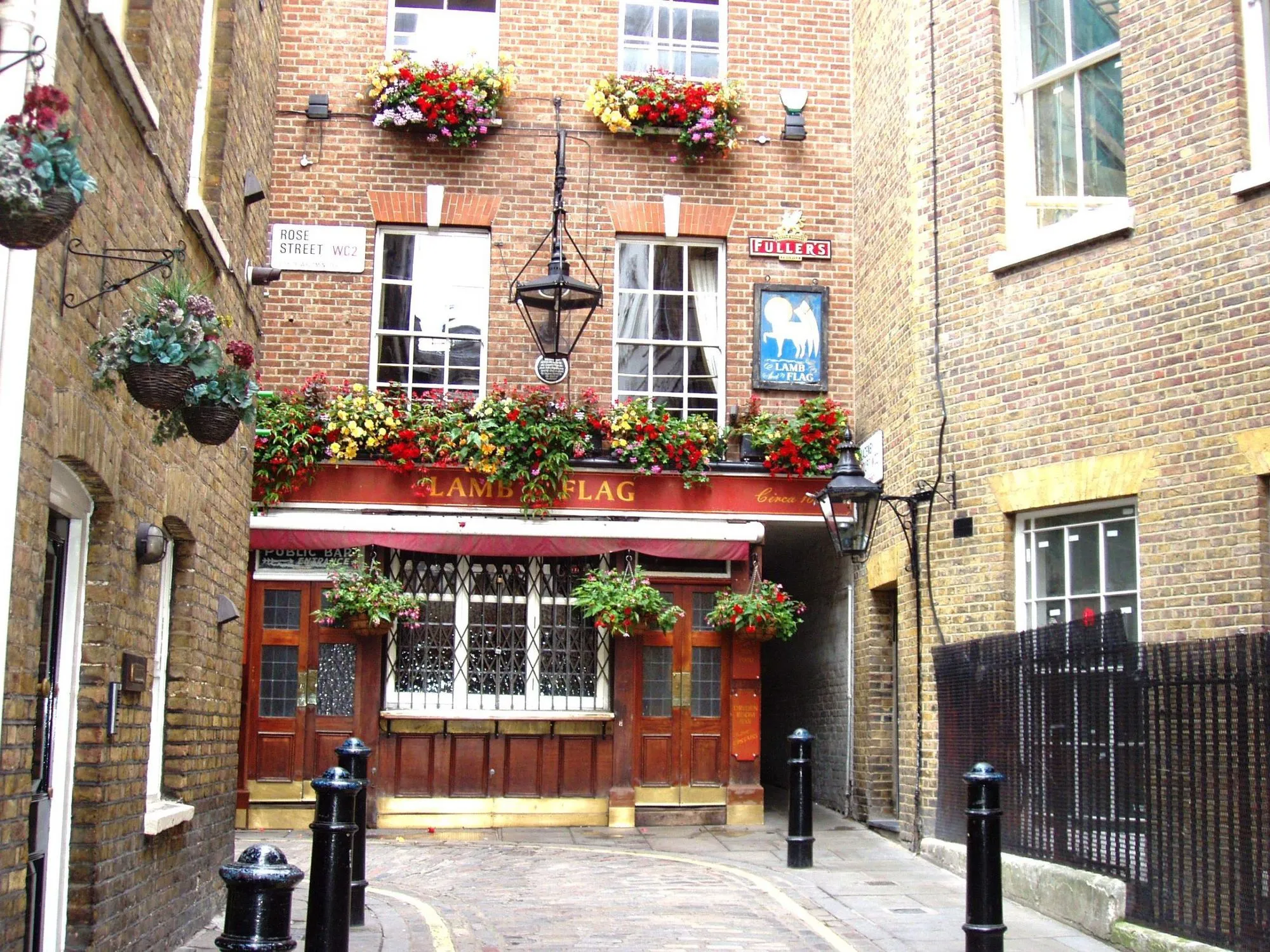 An iconic London pub, 'The Lamb & Flag', nestled in a narrow alleyway, adorned with vibrant flower boxes, showcasing classic British architecture.