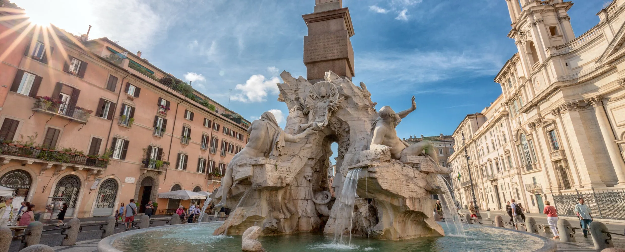 A well-composed and sharp image of the Fountain of Four Rivers in Piazza Navona, Rome, under a clear sky. The intricate details of the statues and the flowing water are clearly visible.