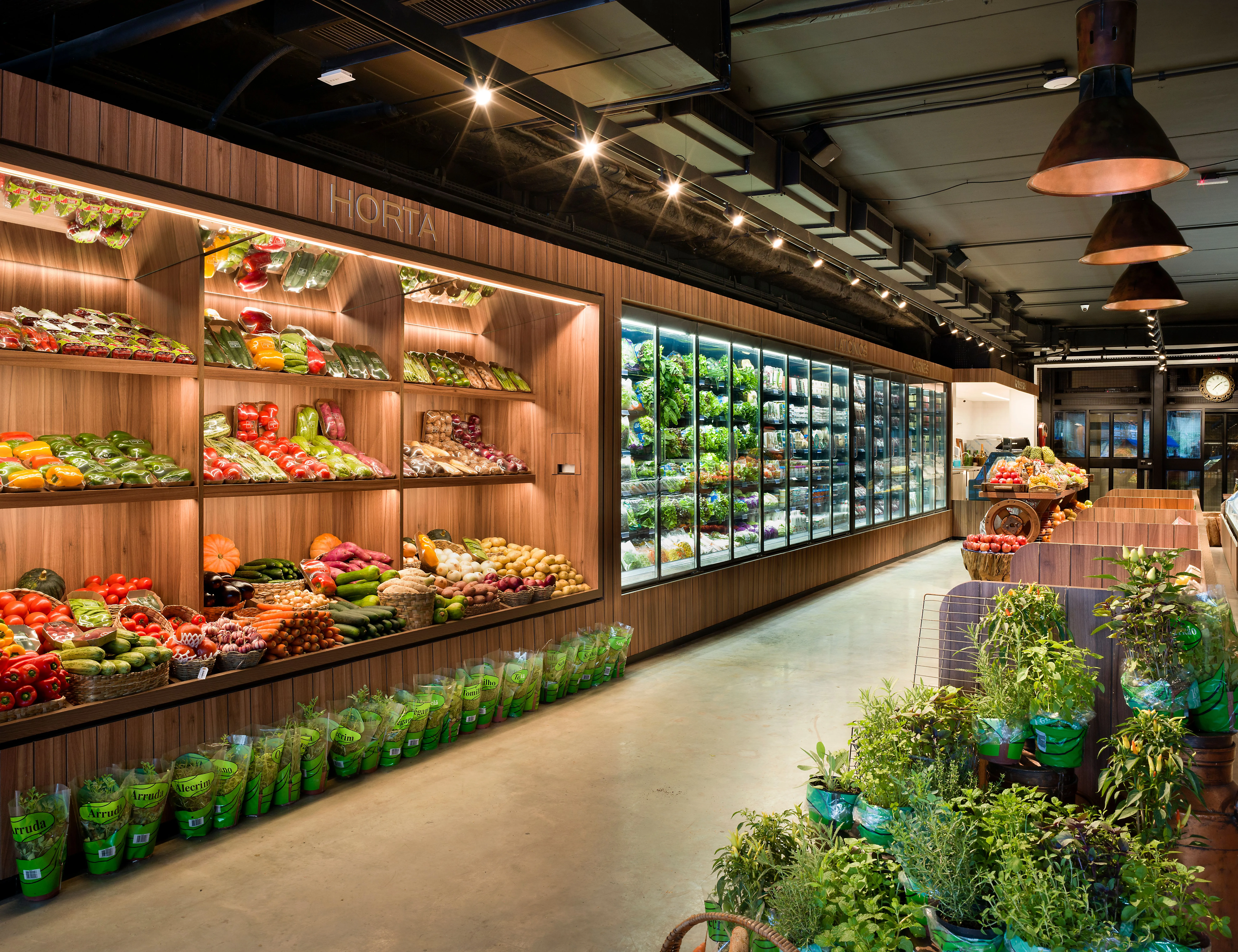 The image showcases a well-composed and brightly lit modern grocery store aisle featuring an abundant display of fresh fruits, vegetables, and greens. The photo is sharp, with accurate and vibrant colors, making the produce appear highly appealing and realistic. All key elements are in focus, contributing to an inviting and clear visual.