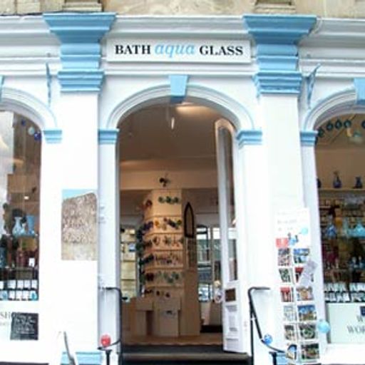 This image is a well-composed shot of a storefront with a clear sign and a visible interior. The lighting is good, though the sharpness could be better, especially on the details in the interior. The colors are accurate and the image is photo-realistic. The key elements, such as the sign and the storefront, are in focus. However, the image contains some unwanted elements, such as the posters on the right side of the image, which detract from the overall aesthetic.