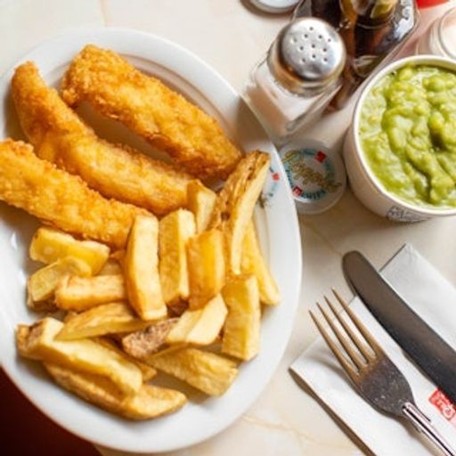 This image is a well-composed, well-lit, and sharp close-up of a plate of fish and chips with peas. The lighting is excellent, highlighting the golden brown color of the fish and chips, and the image is sharp, showcasing the texture of the food. The composition is balanced, with the plate of food in the center of the frame and the peas and cutlery arranged around it. The image is color-accurate, with natural-looking colors. The key elements, including the fish, chips, and peas, are all in focus. The image is photo-realistic, capturing the details of the food and the setting. Overall, this image is a great example of professional food photography.