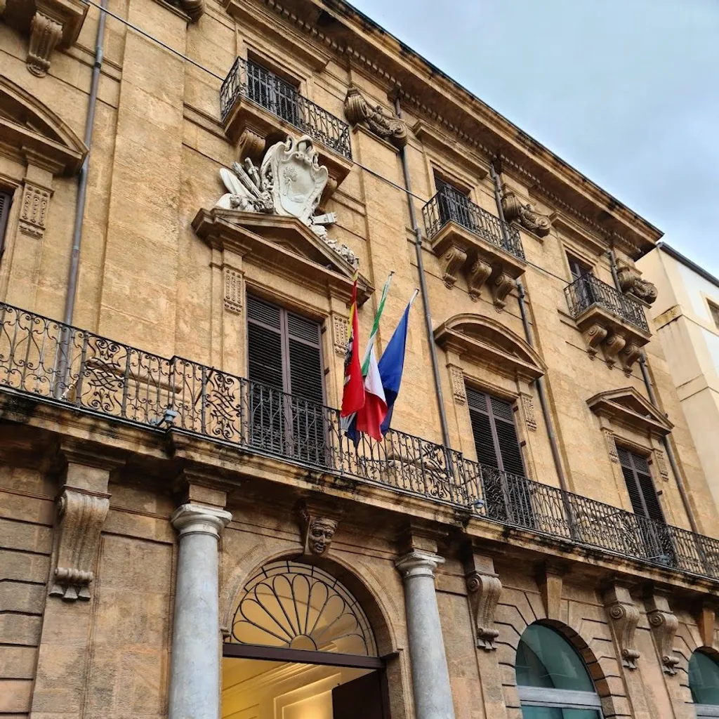 The image is photo-realistic with accurate colors and the key architectural elements, including the building facade, balconies, and flags, are in focus and appear sharp. The composition effectively captures the building. However, the lighting is somewhat flat due to what appears to be an overcast day, which reduces dynamic range and depth compared to more dramatic lighting.