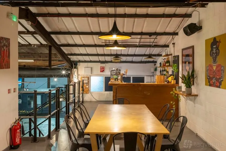 An interior shot of a bar or restaurant with seating, a bar counter, and overhead lighting.