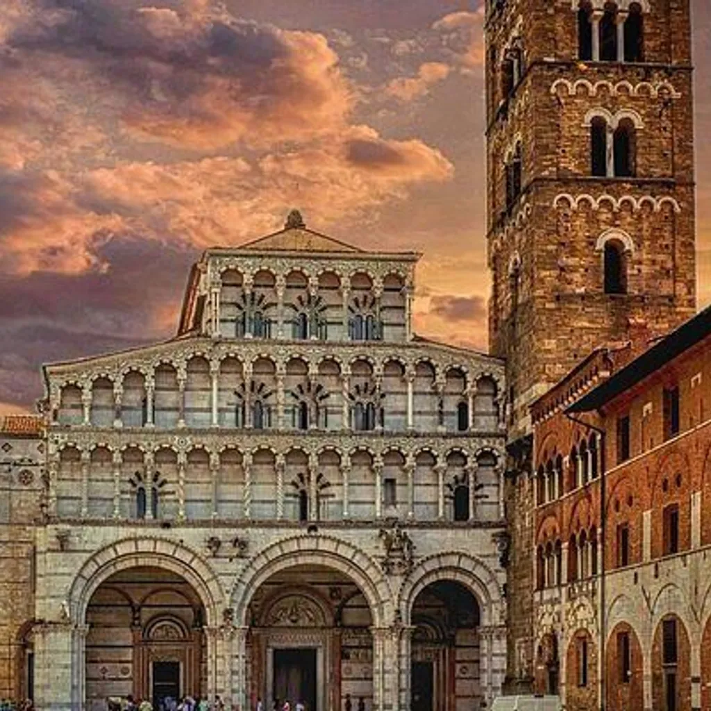 The image prominently features an ornate historical building, likely a church, under a dramatic, colorful sky at what appears to be sunset. The composition effectively highlights the architectural details of the building, which is well-centered and fills a significant portion of the frame. The sky contributes significantly to the mood and visual appeal.