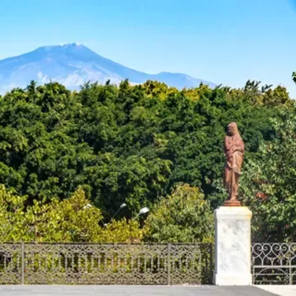 The image features a well-composed landscape with a prominent mountain in the background, lush green trees in the middle ground, and an ornate fence in the foreground. The lighting is good, contributing to natural and vibrant colors. The image is sharp, and key elements are in focus, making it appear photo-realistic. While the composition is good, it isn't exceptionally dynamic.