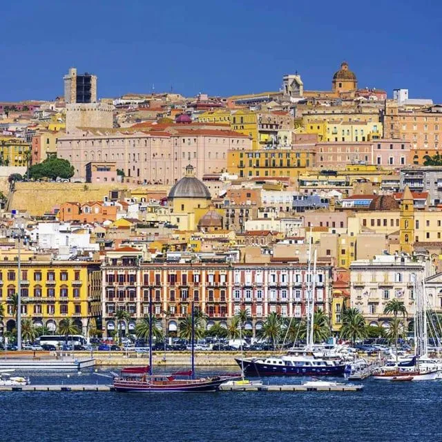 The image is well-composed, showcasing a vibrant cityscape with a clear view of the harbor and buildings. Lighting is good, enhancing the varied colors of the architecture and the blue of the water and sky. The image is photo-realistic with key elements in focus. Minor improvements could be made to the sharpness of the most distant elements and subtle color accuracy.