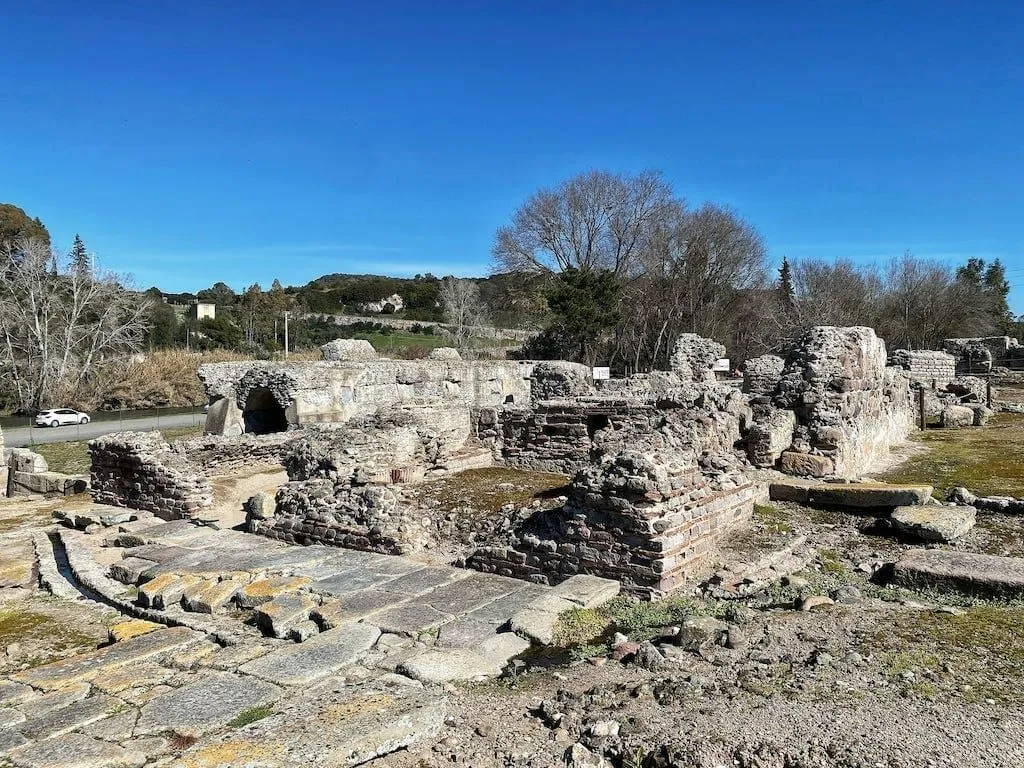 An outdoor shot of ancient stone ruins under a clear blue sky, showcasing an archaeological site.