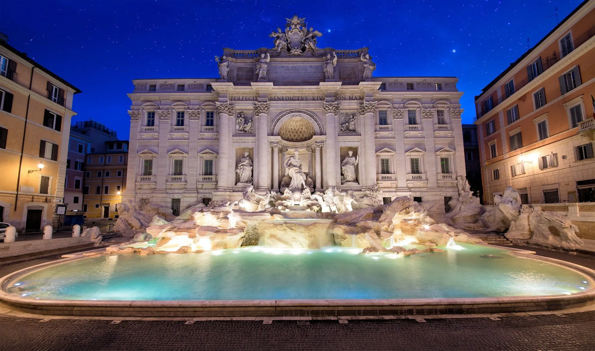 The image beautifully captures the Trevi Fountain at night, showcasing its grandeur. The composition is excellent, centering the entire monument and highlighting its intricate details. The lighting is superb, creating a dramatic and well-illuminated scene. All key elements, including the statues and architectural features, are sharp and in focus. The colors are accurate for a night shot with artificial illumination, and the image is highly photo-realistic, appearing as a professional photograph.