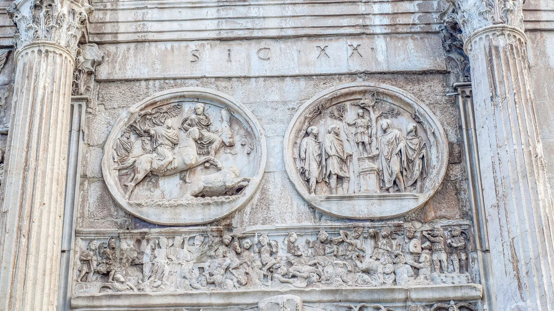 An editorial-style image capturing ancient Roman stone reliefs. The image is sharp with excellent detail, and the lighting is even, highlighting the intricate carvings without harsh shadows. The colors are accurate, reflecting the natural aged appearance of the stone. All key elements are clearly in focus, providing a photo-realistic depiction of the historical monument.