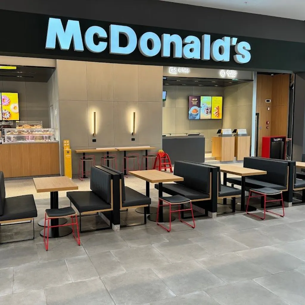 An image of the interior of a McDonald's restaurant, featuring seating areas, the counter, and the prominent McDonald's sign. The lighting is good, and the image is sharp.