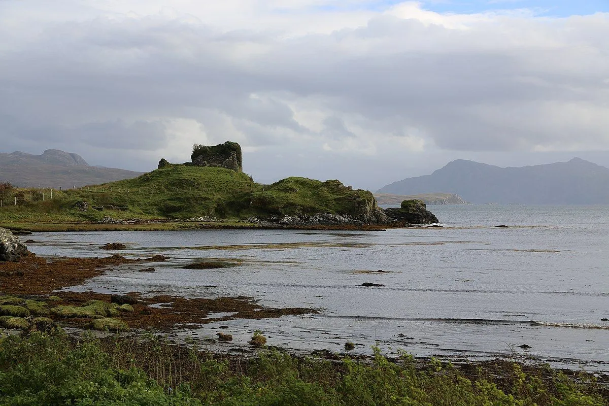 The image is well-composed, featuring a clear subject in the ruins on the island and good overall depth. It is sharp, with key elements in focus, and the colors are accurate for the overcast conditions, contributing to its photo-realistic quality. The primary weakness is the flat lighting due to the overcast sky, which diminishes the visual impact and makes the scene appear somewhat dull.