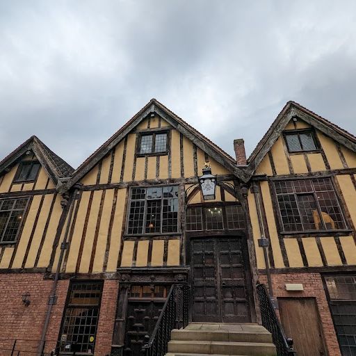 This image is an example of exterior photography. It shows a well-composed shot of a historic building with a focus on the entrance. The image is well-lit with good color accuracy. The sharpness is good, and the key elements are in focus. The image is photo-realistic and captures the details of the building's architecture. The image is free of unwanted elements and meets all the criteria. Overall, the image is of high quality and successfully captures the essence of the building's exterior.