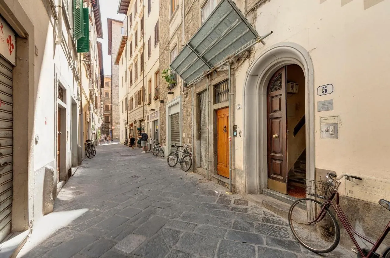 The image showcases good sharpness and photo-realism, accurately depicting the colors of the old street and buildings. Key elements are in focus, contributing to the overall clarity. However, the composition could be slightly improved by avoiding the cutoff of the bike on the far right and the top of the building. The lighting, while generally good, exhibits some harsh contrasts with strong highlights and deep shadows in certain areas of the street.
