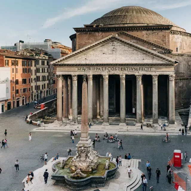 An editorial-style image capturing the Pantheon in Rome, along with the fountain and people in the surrounding piazza. The composition effectively showcases the grandeur of the landmark.