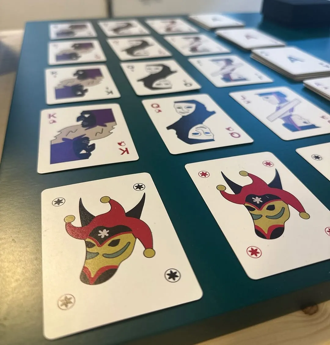 The image is a well-composed photograph of playing cards spread out on a table. The foreground cards are sharp and in focus, effectively using a shallow depth of field to highlight the main subjects. The lighting is natural and even, contributing to the photo-realistic quality. Colors are accurate and vibrant. The composition is generally strong, though the top row of cards is slightly cut off.