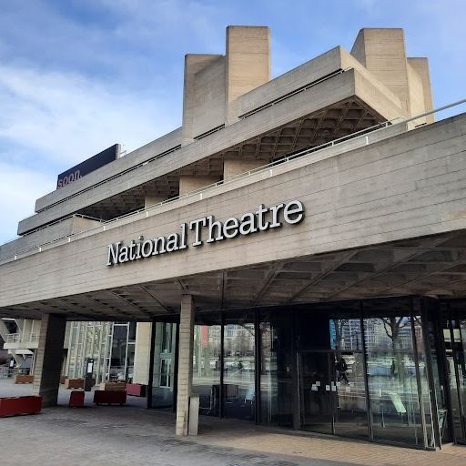 The image is a photograph of the National Theatre on the South Bank in London. It is a brutalist concrete building designed by Denys Lasdun and completed in 1976. The image is well-composed and lit, with the building's striking architecture the main focus. The colours are accurate, and the image is sharp. There are no unwanted elements in the image. Overall, it is a high-quality image that effectively captures the essence of the National Theatre.