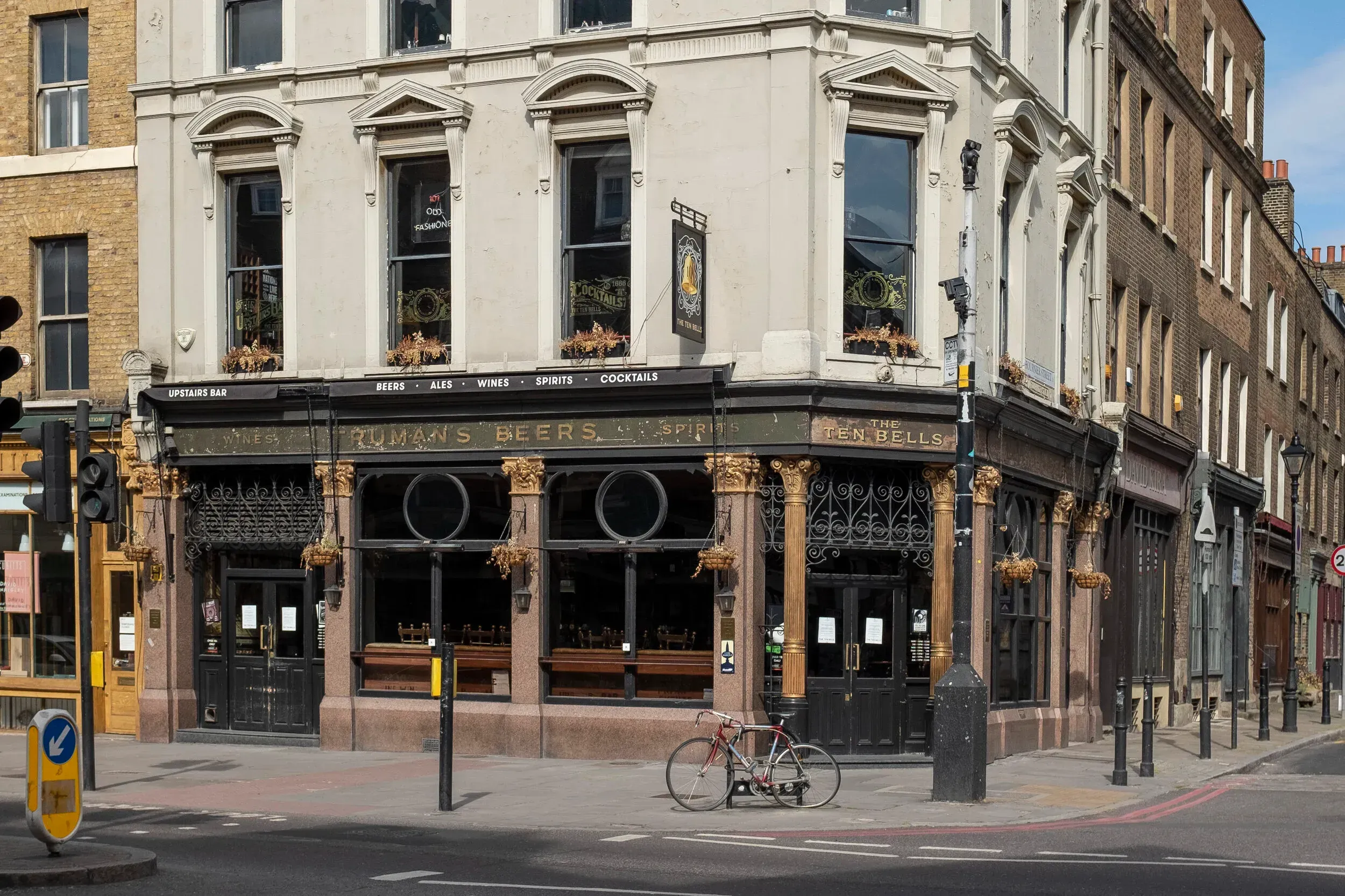An editorial-style image capturing the exterior of 'The Ten Bells' pub. The building is well-composed, sharply focused, and exhibits accurate colors under good natural lighting. The overall impression is highly photo-realistic, with all key architectural details clearly visible and in focus.