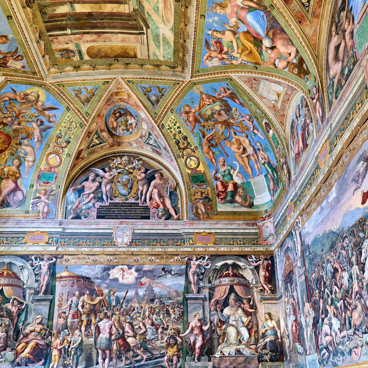 A vibrant and detailed photograph showcasing the elaborate frescoes that cover the walls and vaulted ceiling of a historic room, capturing the intricate details of Renaissance artwork.