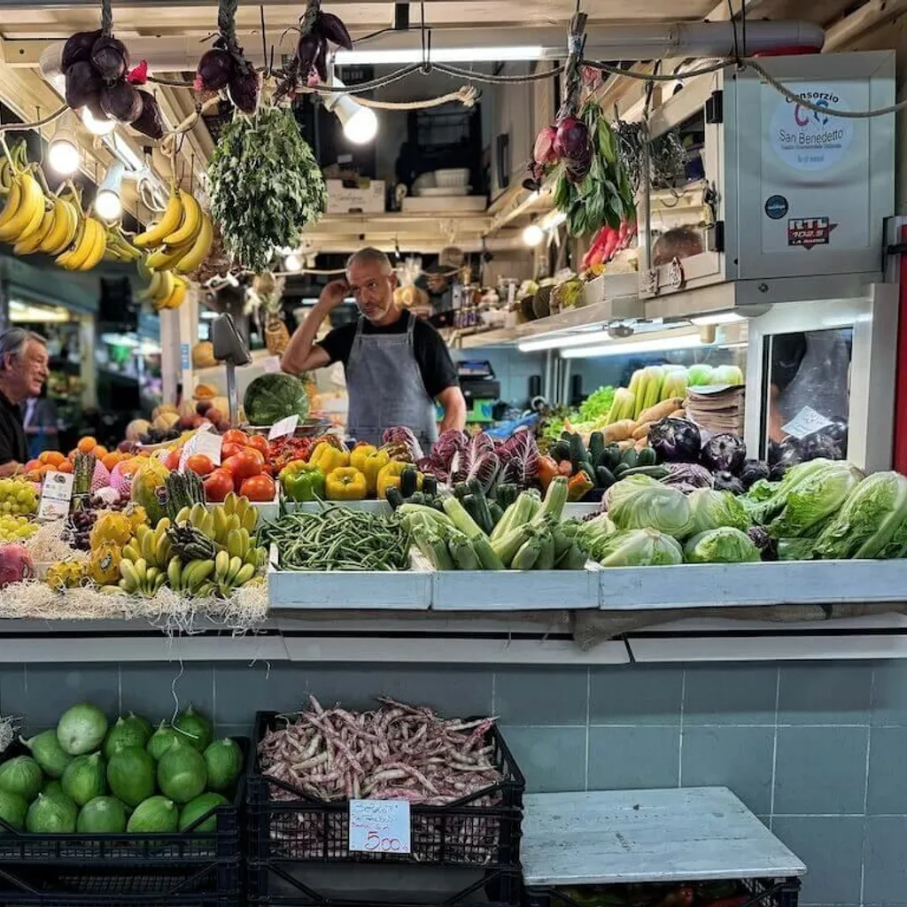 A vibrant and colorful fresh produce market stall, showcasing a wide array of fruits and vegetables, with two market vendors tending to the display. The image captures the authentic atmosphere of a bustling market.