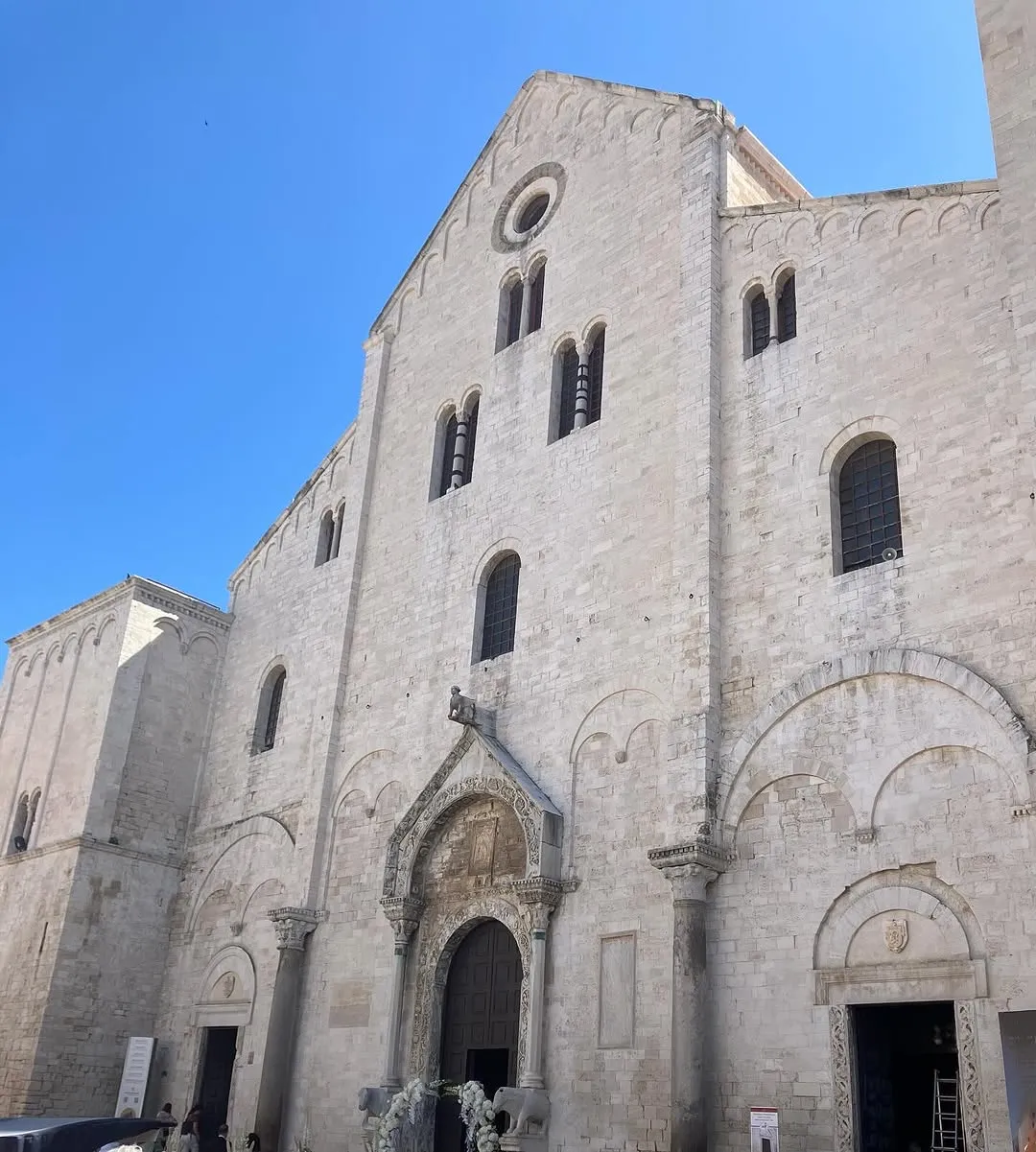 A well-lit, sharp photograph of an old, grand stone cathedral or church under a clear blue sky, highlighting its intricate architectural details.