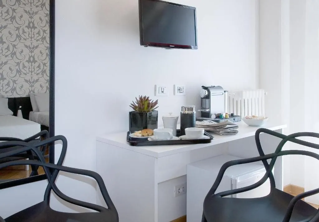 The image is well-composed, clearly showcasing a modern coffee station and amenities in what appears to be a hotel room or suite. The lighting is even and natural, contributing to good color accuracy and a clean aesthetic. All key elements, including the coffee machine, cups on the tray, and plant, are in sharp focus, making the image highly photo-realistic and professional.