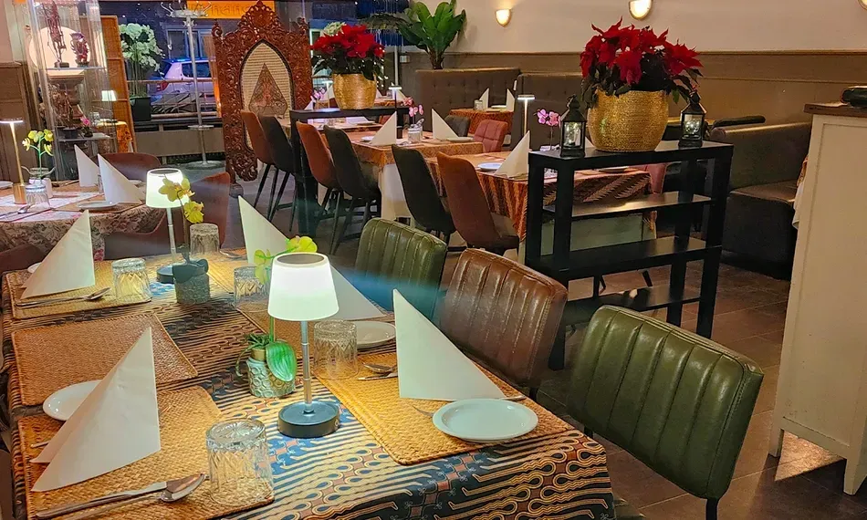 The image successfully conveys a warm and inviting restaurant interior with good ambient lighting. Colors are accurate, contributing to a pleasant atmosphere. While the foreground elements are sharp, the overall composition could be slightly refined for better balance between the foreground and background, and some areas lack absolute crispness. However, the image is highly photo-realistic and effectively captures the intended scene.