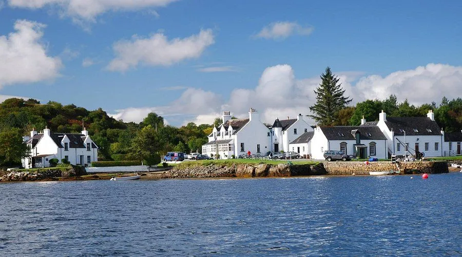The image is well-composed, featuring a white building by a body of water under a clear blue sky. It is well-lit with natural light, resulting in accurate and vibrant colors. The key elements, including the building and water, are generally sharp, contributing to a photo-realistic appearance.