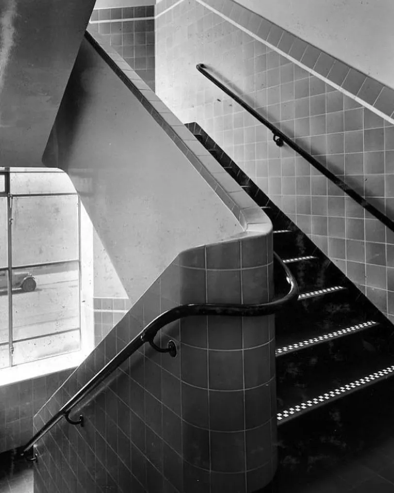 A high-quality black and white architectural photograph capturing a geometric staircase with strong lines and patterns.