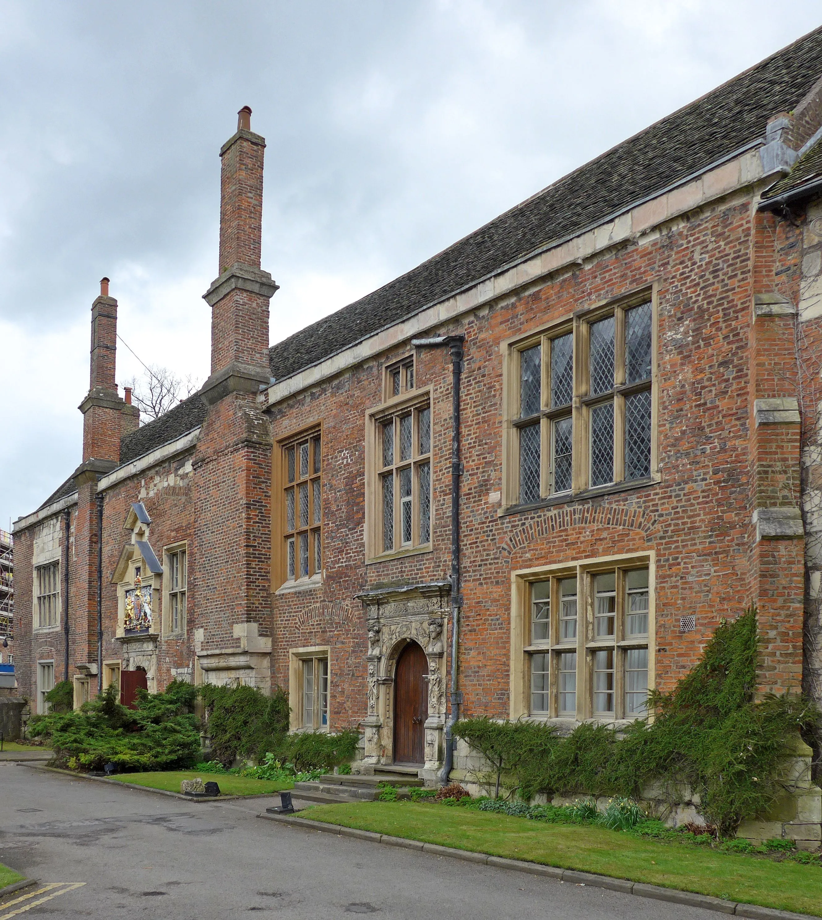 A clear, well-composed photograph of an historic brick building with intricate architectural details, set against an overcast sky.