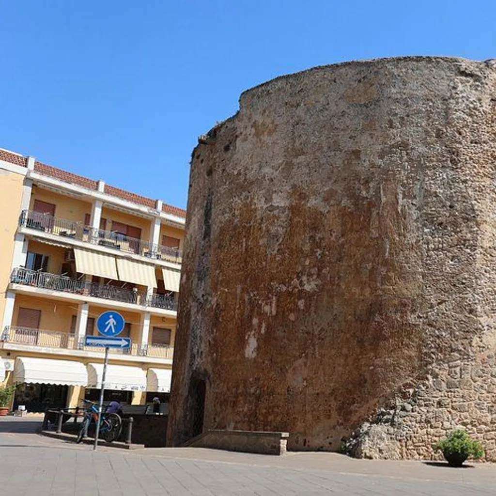 A clear, well-composed photograph of an old stone building or tower under a bright blue sky.