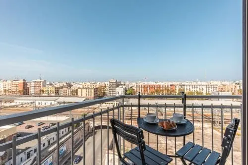 An image captured from a balcony overlooking a city, featuring a small table with breakfast items in the foreground.
