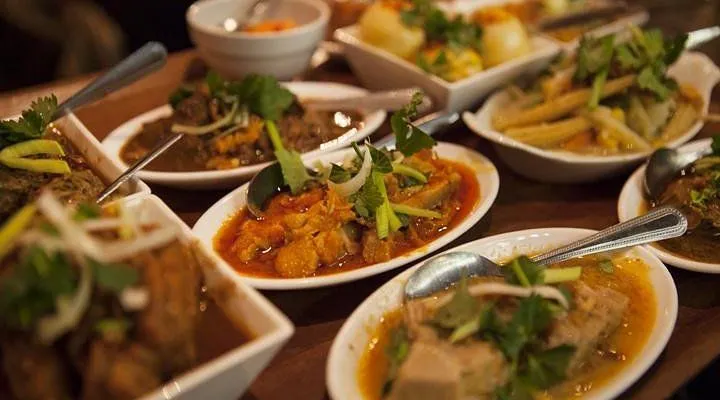 An inviting image of multiple food dishes on a table, with a colorful curry dish prominently featured in the foreground.