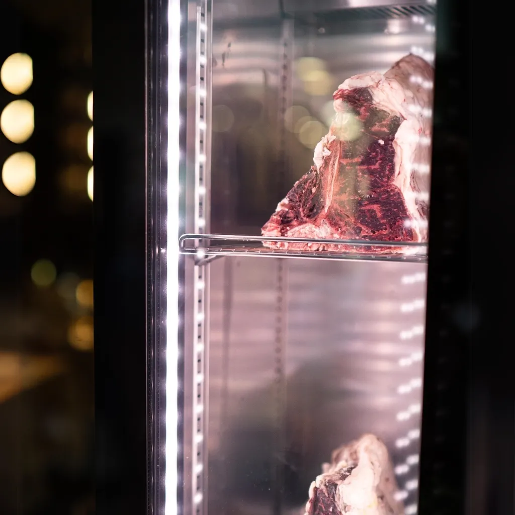 Dry-aged beef displayed in a professional refrigeration unit.