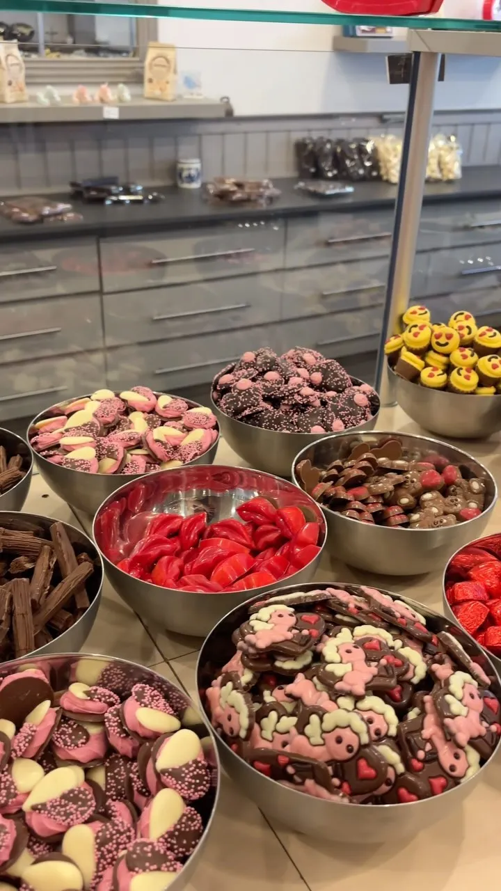 An attractive display of various chocolates and candies in bowls.