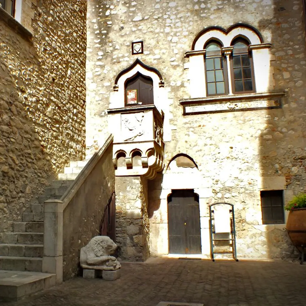 The image is well-composed, effectively showcasing the architectural details of the old stone building, including the staircase, ornate balcony, and lion statue. Key elements are sharp and in focus, contributing to its photo-realistic quality. However, the image suffers from harsh lighting, which results in strong shadows and blown-out highlights, diminishing overall detail and dynamic range. The color accuracy could also be improved, as the image has a slightly desaturated and warm cast.