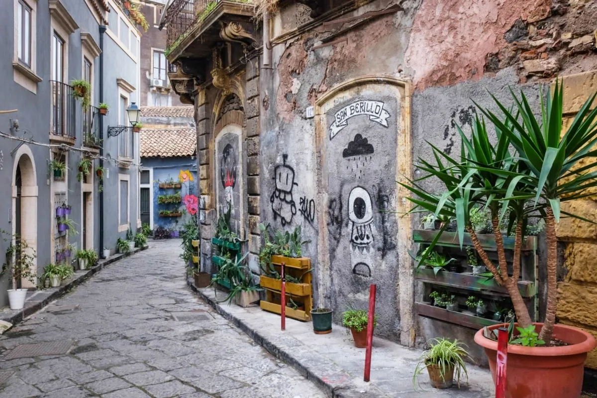 The image is a well-composed and sharp photograph of an old street scene. It features excellent, even lighting that highlights the textures of the weathered buildings and cobblestones. All key elements are in sharp focus, contributing to a high degree of photo-realism and accurate colors. The composition effectively uses leading lines and depth, creating an engaging view of the urban environment.