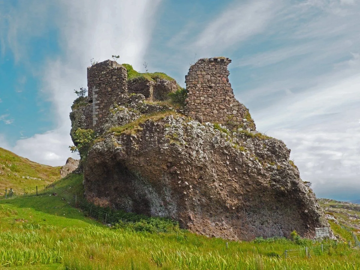 A well-composed and sharp photograph of ancient castle ruins perched atop a large rock formation. The lighting is good, enhancing the textures of the stone and rock, and the colors are natural and vibrant.