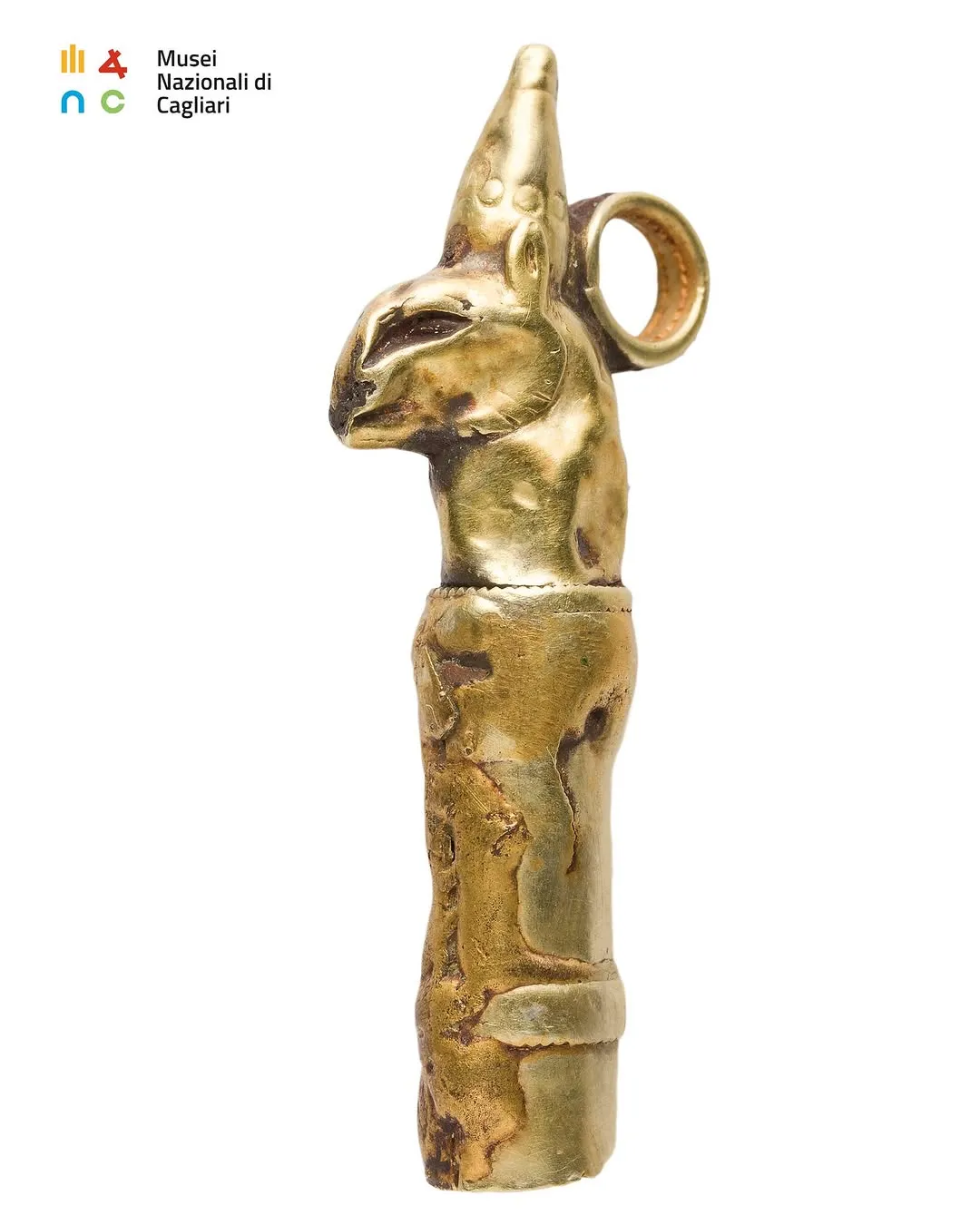A close-up, professionally taken photograph of a golden or brass artifact featuring an animal head, set against a plain white background.