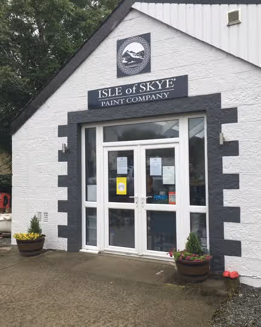 The image shows the exterior of the Isle of Skye Paint Company. The composition is decent, focusing on the storefront. The lighting appears adequate, though perhaps a bit flat. Sharpness is acceptable, but not exceptional. Color accuracy seems reasonable. The image is photo-realistic. The key elements, such as the store name and entrance, are in focus. The image is slightly let down by the composition and sharpness. The image is not cluttered and does not contain any unwanted elements.