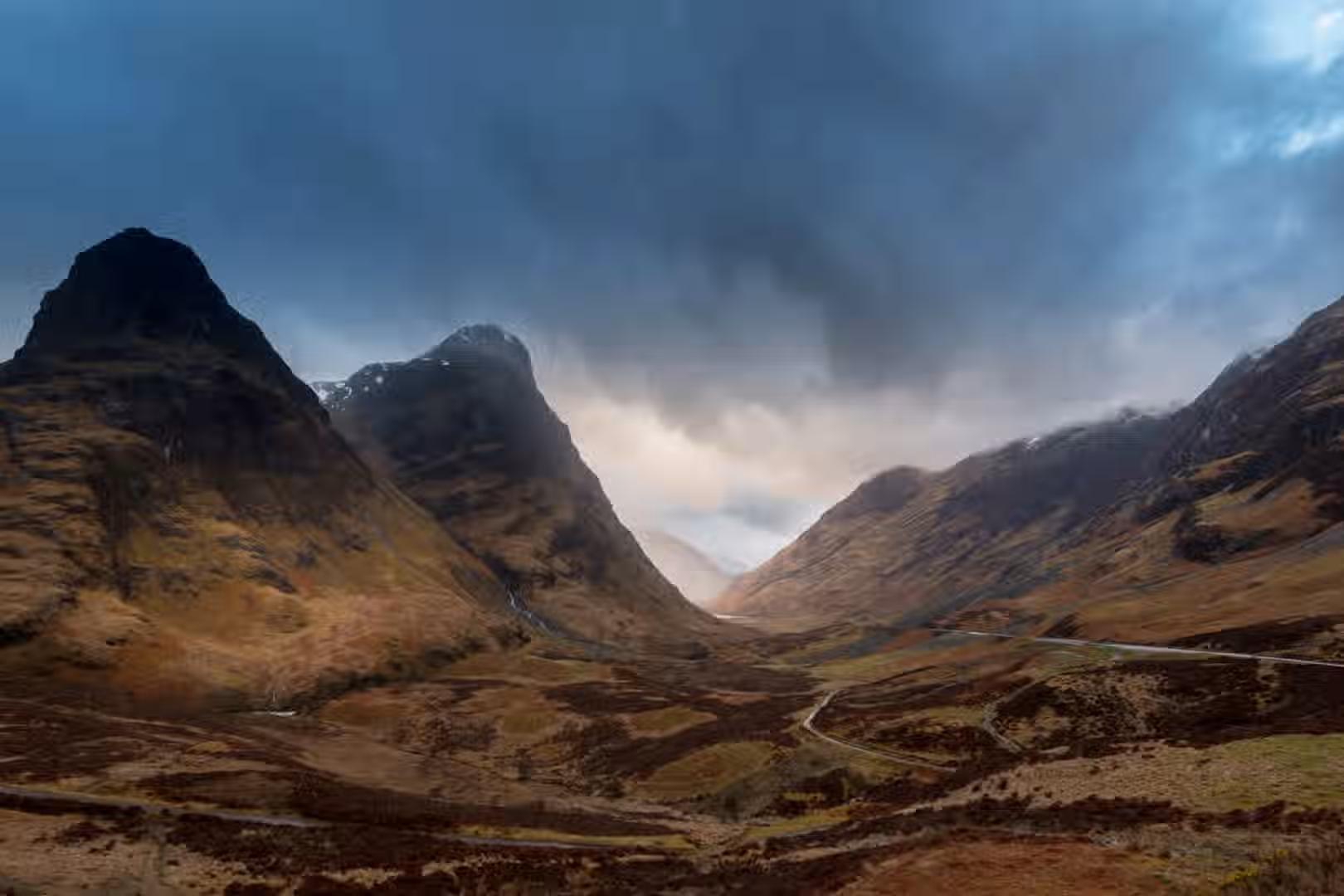The image is well-composed, showcasing a scenic mountain valley with dramatic cloud cover. The lighting is effective, creating a sense of depth and atmosphere. The image is generally sharp, with the key elements in focus. The colors appear accurate, capturing the natural tones of the landscape. The photo-realism is high, making the scene appear authentic. Strengths: Well-composed, good lighting, sharp focus on key elements, color-accurate, and photo-realistic. Weaknesses: None apparent.