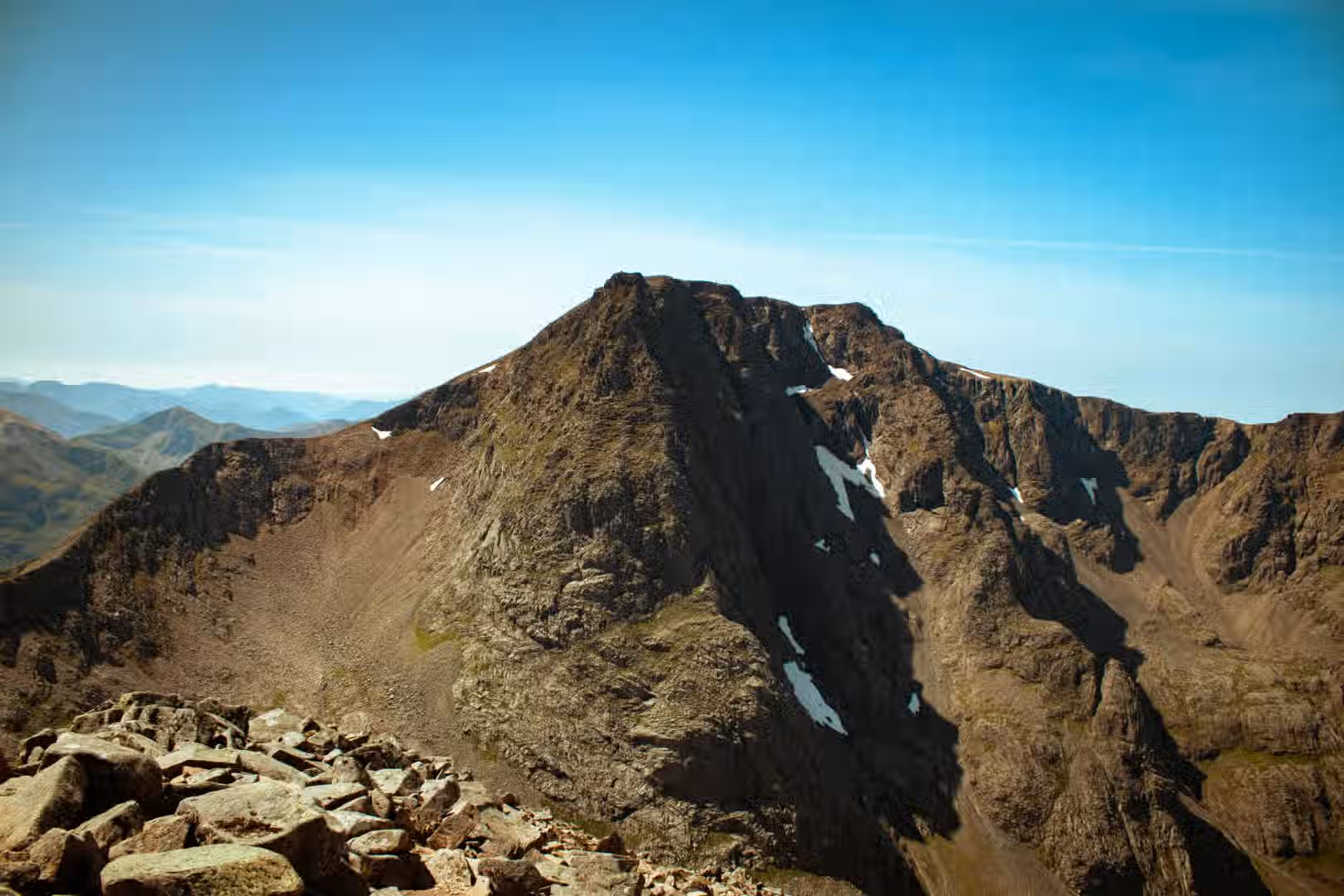 The image is well-composed, showcasing a mountain peak against a clear blue sky. The lighting is good, with clear visibility and distinct shadows. The sharpness is decent, allowing for some detail in the rock formations. Color accuracy seems appropriate, with natural tones in the landscape and sky. The image is fairly photo-realistic. The key elements, such as the mountain peak, are in focus. The overall score reflects the strengths in composition, lighting, and color accuracy, with minor deductions for sharpness and photo-realism.