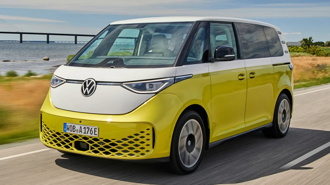 Vue 3/4 avant et latérale de la Volkswagen ID.Buzz 2022 sur route avec vue sur mer