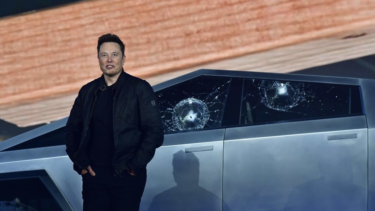 Elon Musk à côté d'une tesla.