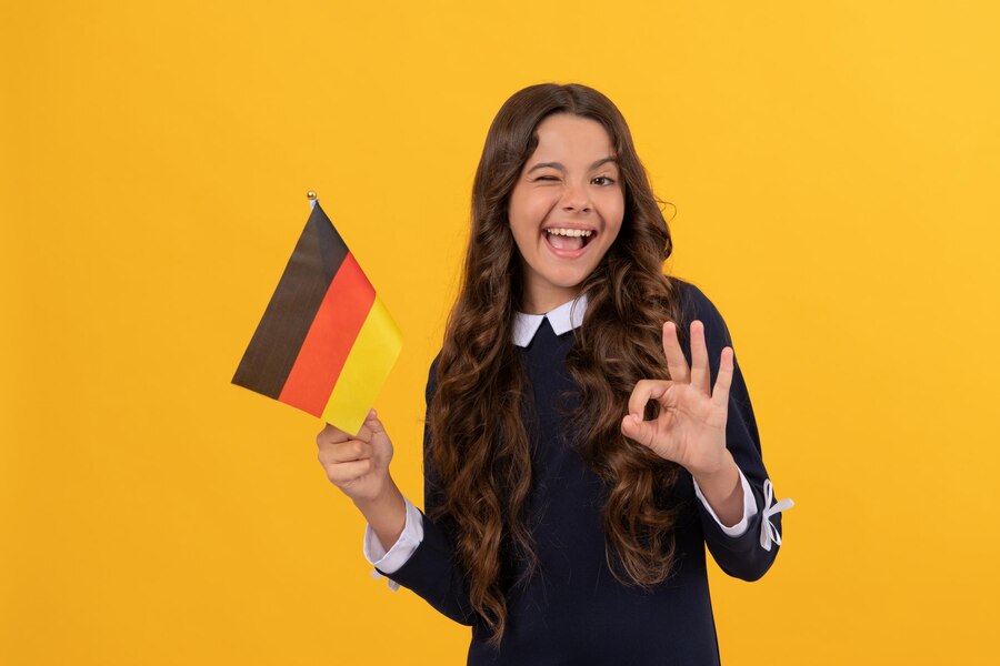 Young girl studying German with colorful books at table
